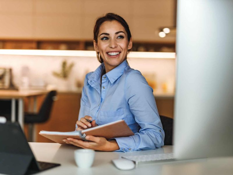 Smiling at monitor, looking happy.